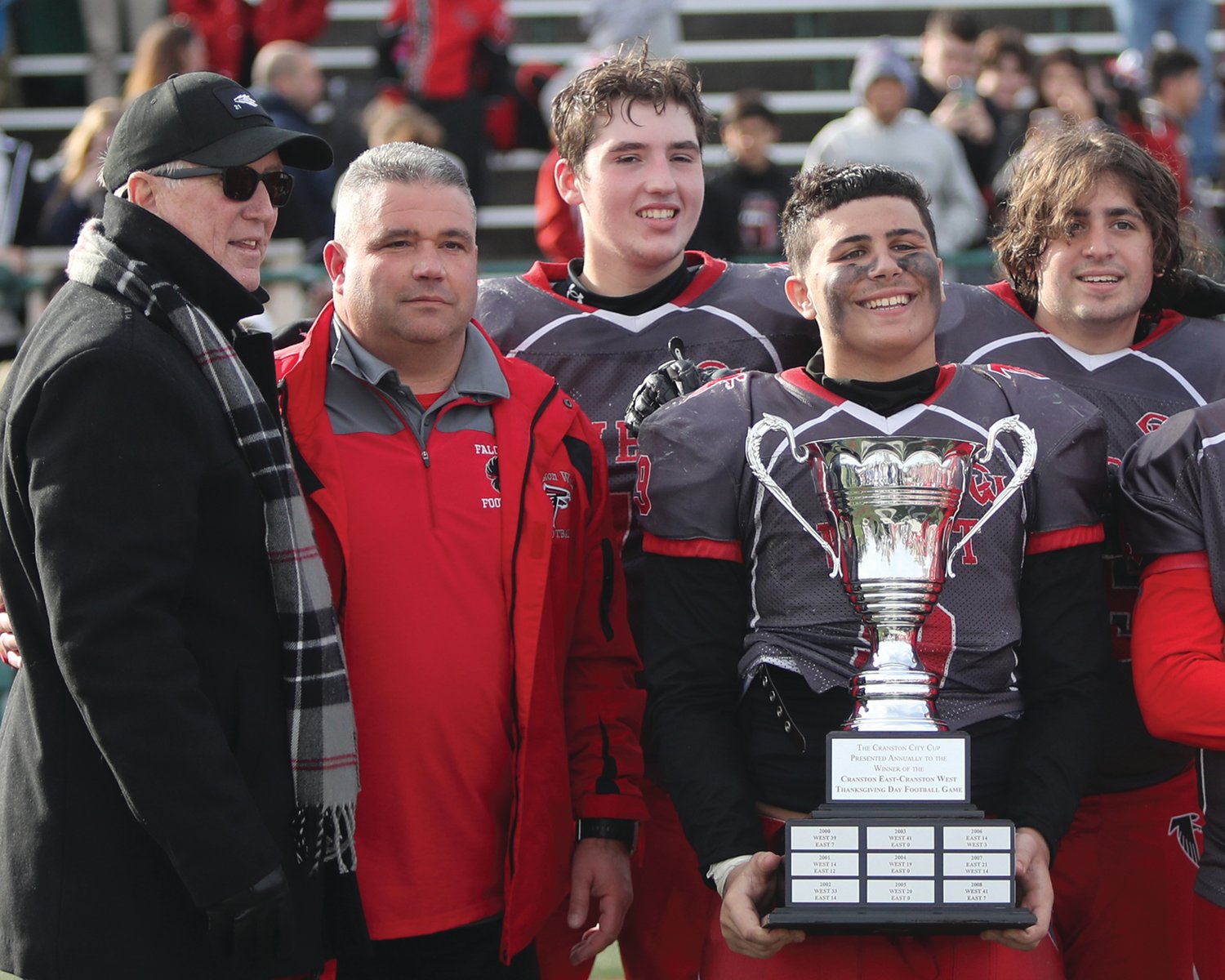 GETTING THE WIN: Cranston Mayor Ken Hopkins (far left) presents the Thanksgiving trophy to West’s Tom Milewski,
Jacob Robert, Teddy Shakelford and Anthony Perrotta.